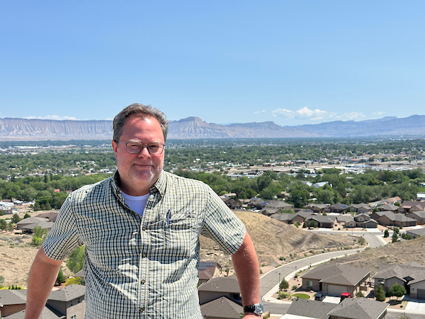 eric elder stands in front of a large landscape